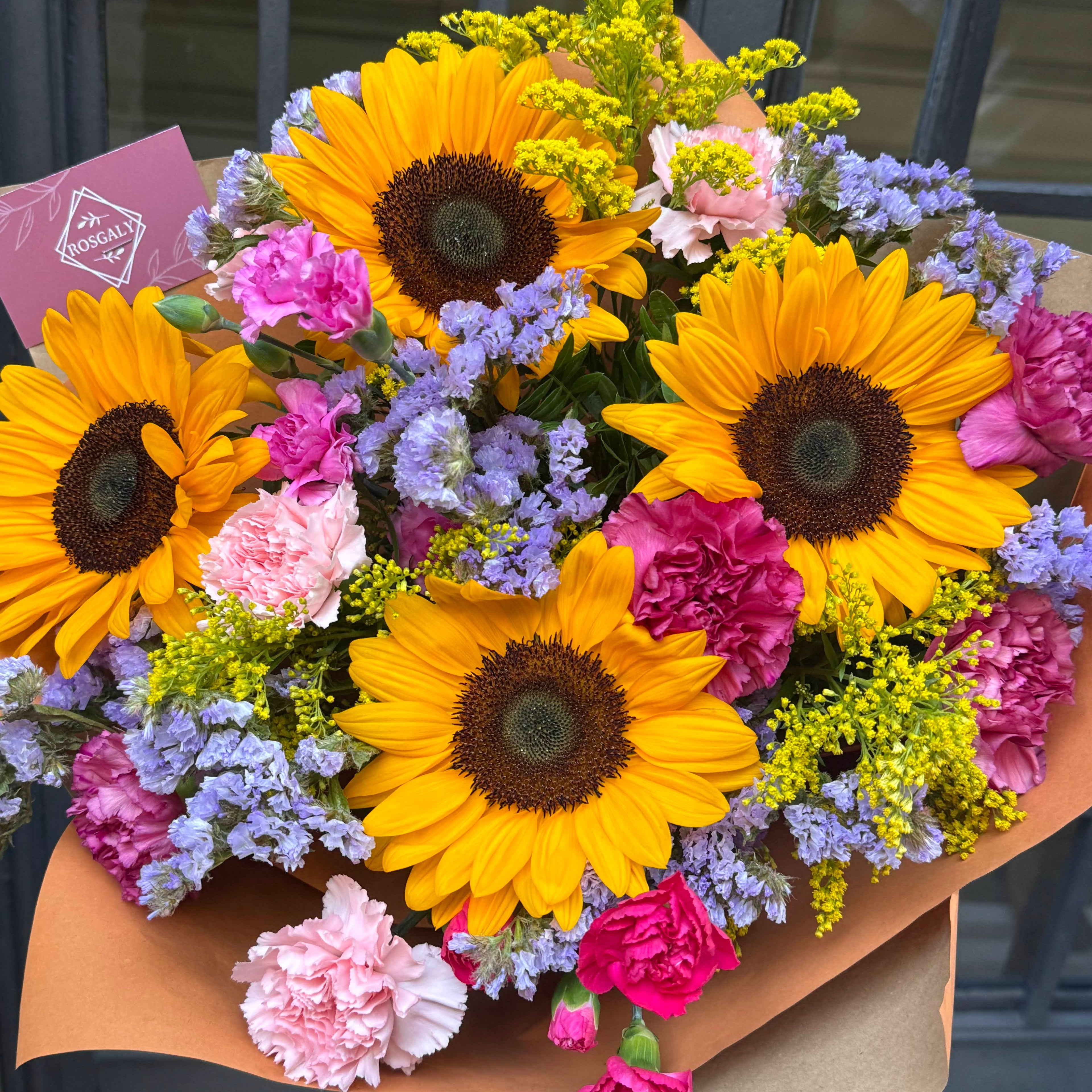 Ramo Soleil con girasoles, claveles fucsia y statice lila en papel kraft — Rosgaly Floristería Barcelona